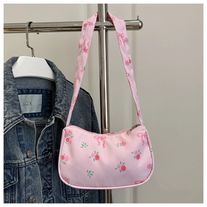 Detail view of pink strawberry canvas shoulder bag with red rose and ribbon bow patterns