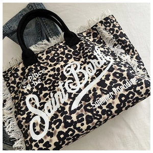 Detail shot of leopard print canvas tote bag with white fringe and Saint Barth branding