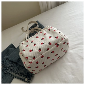 Détail de la texture d'un sac cabas en velours côtelé blanc à motifs de fraises