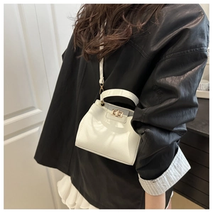 Macro shot of white lychee texture bucket bag with gold clasp and elegant metal hardware