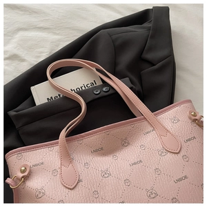 Detail of pink tote bag with cartoon animal prints and litchi grain texture finish