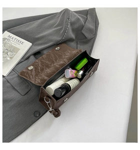 Interior view of brown faux leather handbag showing capacity for cosmetics and accessories