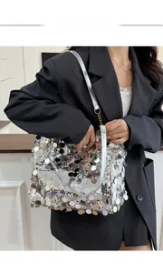Detail of silver sequin shoulder bag showing reflective mirror discs and leather strap