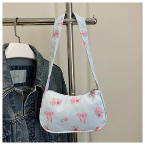 Detail of light blue floral shoulder bag with pink roses and ribbon bow prints