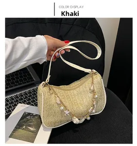 Détail du sac en paille tissée avec bordure en cuir blanc et chaîne à perles marines