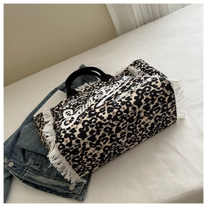 Detail of leopard print canvas tote with white fringe trim and Saint Barth branding