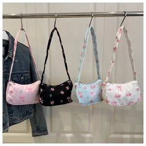 Detail of canvas shoulder bags featuring floral rose patterns and bow prints in four colors