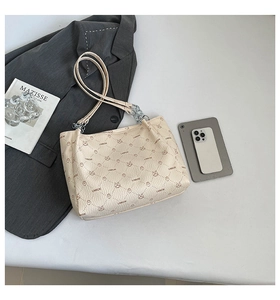 Detail of cream leather tote bag with rabbit print and metal chain for office commute