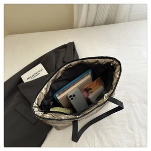 Detail of spacious gold tote bag interior showing pockets and large storage capacity