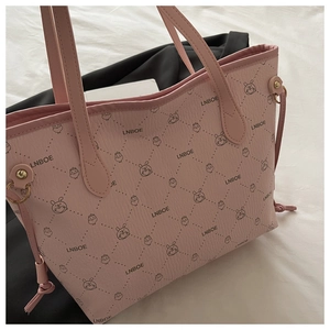 Close-up of pink tote bag with litchi texture and cartoon rabbit diamond pattern detail