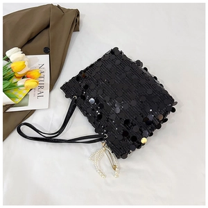 Detail of a black sequin shoulder bag with pearl pendant and shiny reflective texture