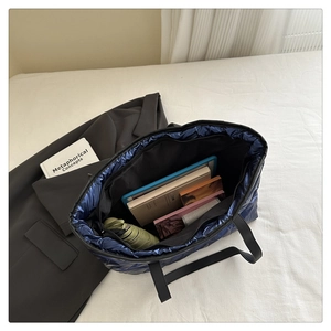 Interior view of spacious blue quilted tote bag holding a tablet and daily essentials