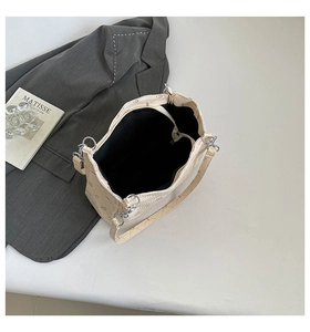 Top view of beige tote bag showing spacious black interior and silver metal hardware