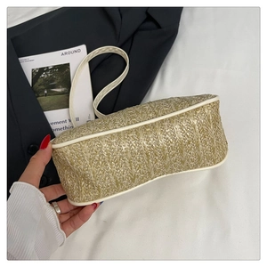 Gros plan sur la texture tissée en V du sac à bandoulière en paille avec liseré blanc