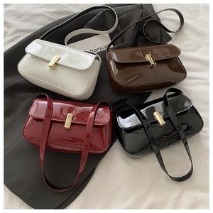 Flat lay of glossy patent leather crossbody bags in four colors with gold metal buckles