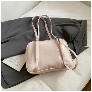 Detail of light pink glossy PU leather shoulder bag with sleek bow and thin strap