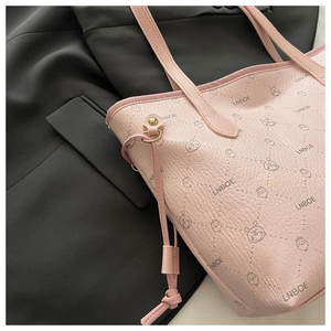 Detail of pink tote bag with litchi texture and cute cartoon rabbit print on black blazer