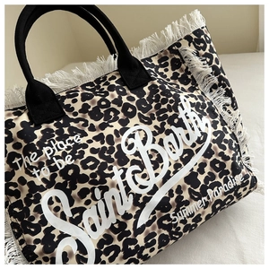 Close-up of leopard print canvas tote bag with white fringes and Saint Barth logo