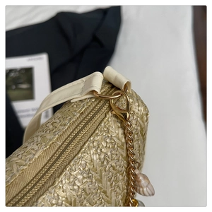 Détail du sac en paille tressée avec chaîne dorée et pendentif perle coquillage