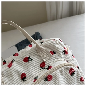 Détail de l'imprimé fraises sur sac en velours côtelé avec fermeture éclair et anse