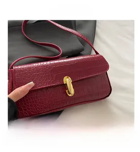 Close-up of deep wine red retro underarm bag with crocodile pattern and gold buckle