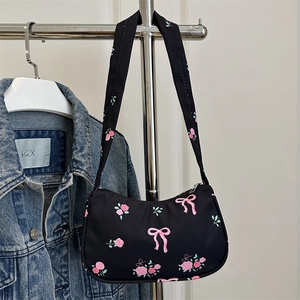 Floral print black shoulder bag with pink roses and bow design in crescent shape