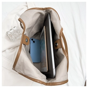 Interior view of brown tote bag showing large capacity for laptop, tablet and smartphone