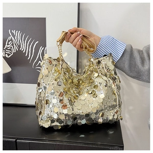 Detailed close-up of golden sequin mini bag with metallic chain and leather strap
