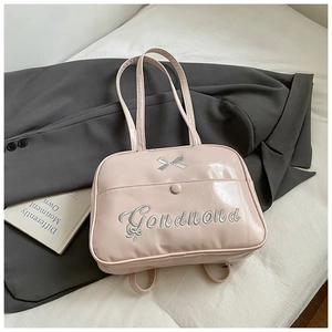 Detail of pink patent leather handbag with silver bow and Gondnond embroidery