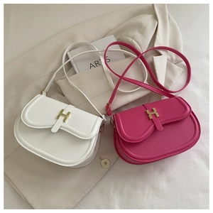 Close-up of matte leather handbag featuring iconic golden H-shaped buckle detail