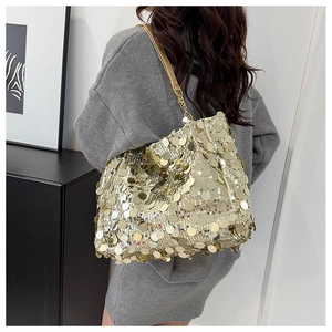 Detail of shimmering gold sequin tote bag with chain strap and metallic finish