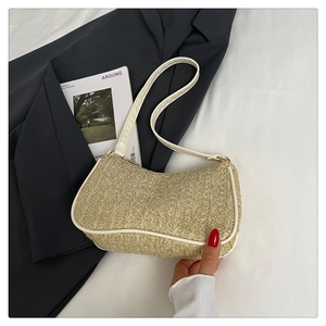 Détail du sac sous l'aisselle en paille beige avec bordure en cuir blanc et sangle