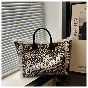 Detail of leopard print canvas tote bag featuring fringe edges and Saint Barth lettering