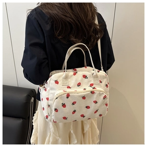 Détail du sac à lunch en velours côtelé à motif fraises avec bretelles réglables