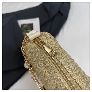 Gros plan sur la texture en paille tressée avec chaîne de perles et zip doré élégant