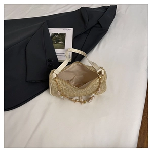 Détail d'un sac en paille avec chaîne en perles et coquillages et fermeture éclair