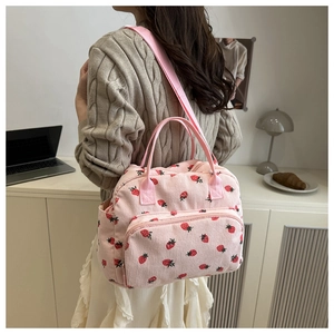 Sac bandoulière en velours côtelé rose à imprimé fraise dans un décor quotidien