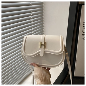 Detail view of white leather saddle bag with golden H-shaped clasp and matching shoulder strap