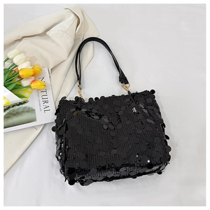 Detail of black sequined tote bag with golden metal buckle and sleek leather shoulder strap