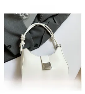 Detail of white hobo handbag showing silver metal buckle and knotted strap design