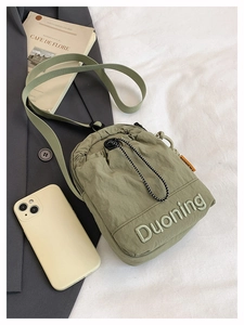 Detail of army green nylon drawstring bag with premium embroidery and fashion label
