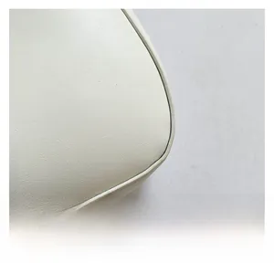 Close-up of premium white leather texture and smooth rounded edge detail on handbag