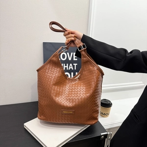 Brown woven hobo shoulder bag with matte leather finish and silver metal ring accents