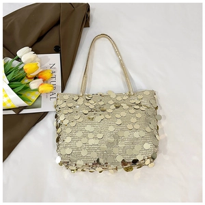 Flat lay of gold sequin tote bag with yellow tulips on white and brown background