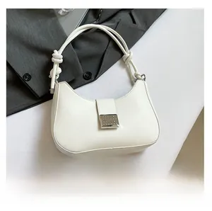 Macro detail of white crescent hobo bag with knotted handle and silver metal snap closure