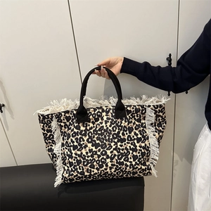 Large denim tote bag with leopard print, white fringe edges and sturdy black handles