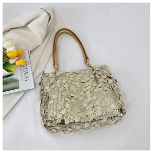 Close-up of golden sequins on a luxury tote bag with chain strap and leather handle