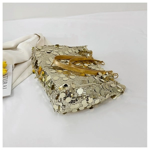 Detailed view of shimmering gold sequins on a stylish evening bag with leather handles