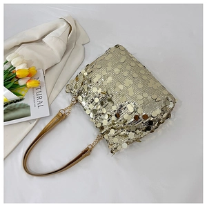 Detailed macro of champagne gold sequin texture and mixed chain strap on small square bag