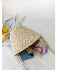 Detail showing inner capacity of beige hand-woven bucket bag with pearl accent